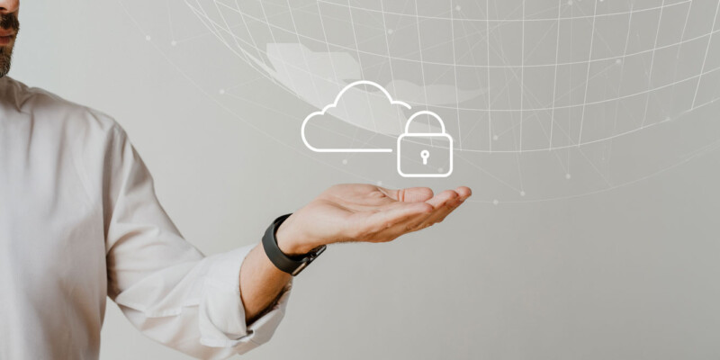Geschäftsmann, der ein Cloud-Symbol mit einem Vorhängeschloss hält, das Cloud-Sicherheit oder Datenschutz symbolisiert.